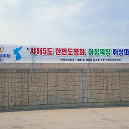 Надпись на баннере: «Мир для пяти остров Желтого моря и Корейского полуострова, расширение рыбопромысловых площадок, реальное создание рыбного рынка на воде». Фото с сайта ohmynews.com