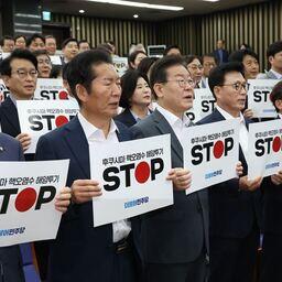 Депутаты Демократической партии Тобуро держат плакаты, призывающие Японию отменить сброс воды с АЭС «Фукусима» в океан. Заседание Национальной ассамблеи в Сеуле. Фото информагентства Yonhap