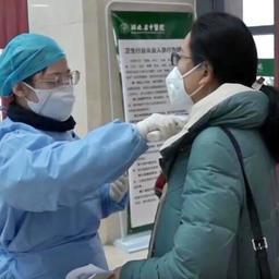 Медсестра в китайской больнице меряет температуру посетительнице. Фото China News Service. Файл доступен по лицензии Creative Commons Attribution 3.0 Unported