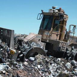 Трактор утрамбовывает мусор на свалке. Фото Ropable («Википедия») 